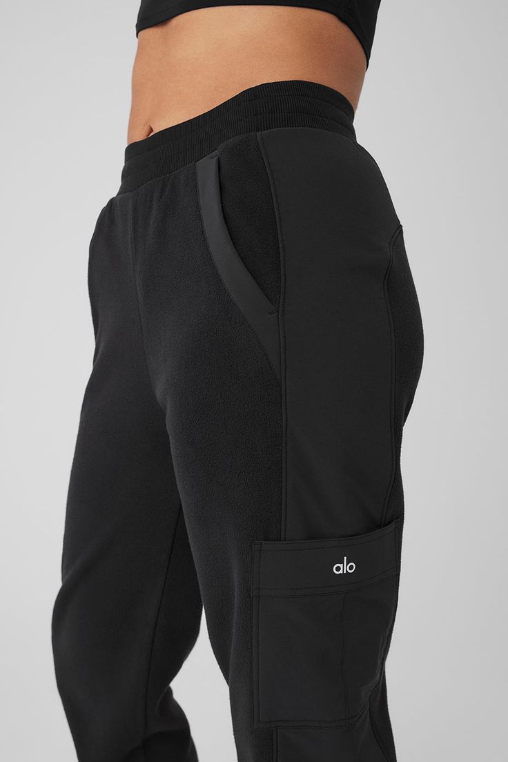 Made from a fleecy-soft fabric with smooth, contrasting panels down the legs, these pants are every bit as cozy as they look. They have a total of 4 pockets—2 on the sides, 2 on the legs—plus a stretchy high-rise waistband and stretchy cuffed hems for a jogger-style fit. Our advice? Get the matching jacket, too. Alo Yoga Pants With Pockets, Alo Yoga Athleisure Pants With Pockets, Sporty Alo Yoga Pants With Pockets, Sporty Alo Yoga Bottoms With Pockets, Sporty Alo Yoga Bottoms With Comfort Waistband, Alo Yoga Sporty Bottoms With Comfort Waistband, Alo Yoga Functional Black Bottoms, Functional Black Joggers With Pockets, Black Cargo Sweatpants For Loungewear