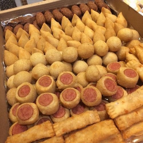 a box filled with lots of different types of pastries next to other food items