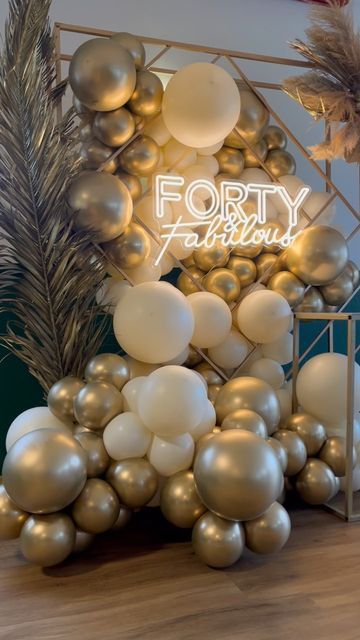 balloons and palm leaves are on display in front of a forty birthday sign