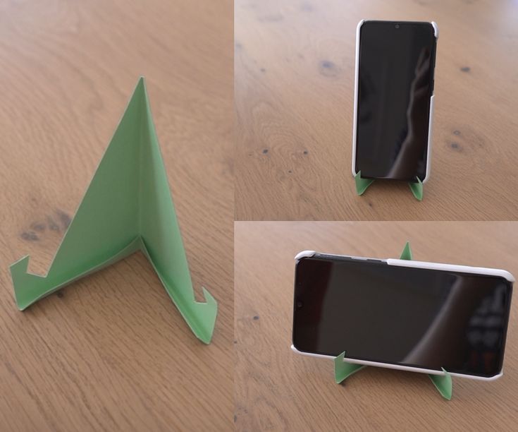 four different angles of an origami cell phone holder on a wooden table top