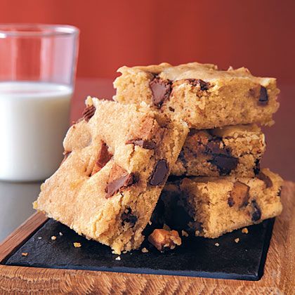 chocolate chip cookie bars stacked on top of each other next to a glass of milk