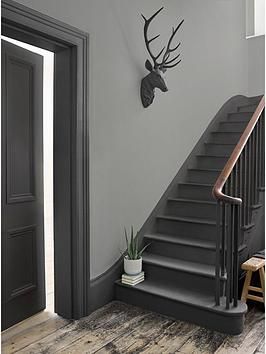 an entry way with stairs and a deer head on the wall