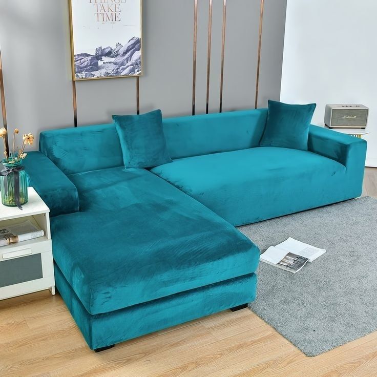 a large blue couch sitting on top of a wooden floor next to a white table