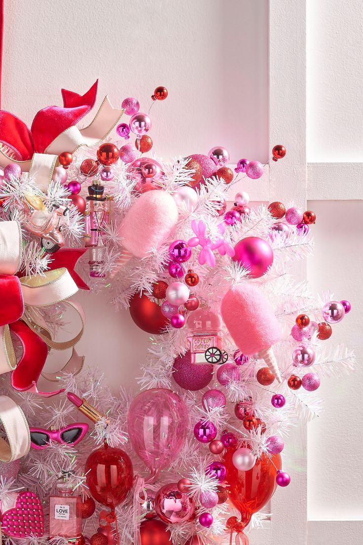 a christmas wreath with pink and red ornaments