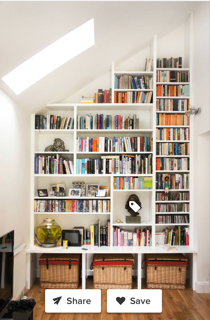 the bookshelves are full of books and have baskets under them to store them