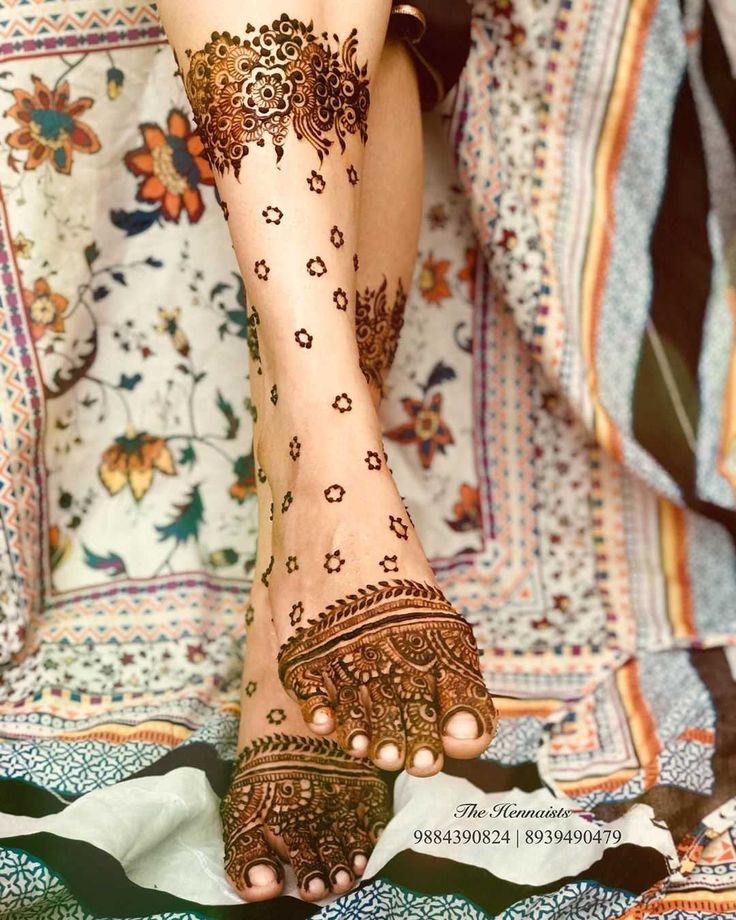 the legs and feet of a woman with henna tattoos