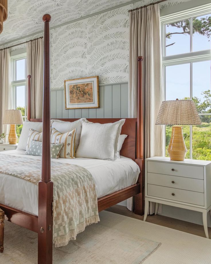 a bedroom with a four poster bed and two lamps on either side of the bed