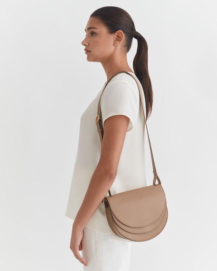 Our sculptural Double Moon Saddle Bag is crafted with practical details of two compartments, a back slip pocket, an easy magnetic closure, and an adjustable strap for crossbody and shoulder carrying. | Made in Turkey from soft and supple leather with a pebbled texture. Our luxurious leather wears well over time and only gets better with age. | Leather Working Group is the world's leading environmental certification for the leather industry. It affirms that our leather is tanned in an environment Luxury Crossbody Saddle Bag For Everyday, Luxury Everyday Crossbody Saddle Bag, Chic Saddle Bag With Gold-tone Hardware For Travel, Everyday Saddle Bag With Detachable Strap, Timeless Saddle Bag With Adjustable Strap, Chic Saddle Satchel For Travel, Luxury Saddle Bag Satchel For On-the-go, Timeless Everyday Saddle Bag With Removable Pouch, Modern Soft Leather Saddle Bag With Top Handle