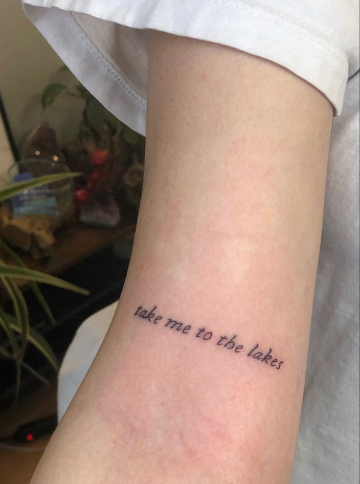 a person with a tattoo on their arm that says take me to the labies