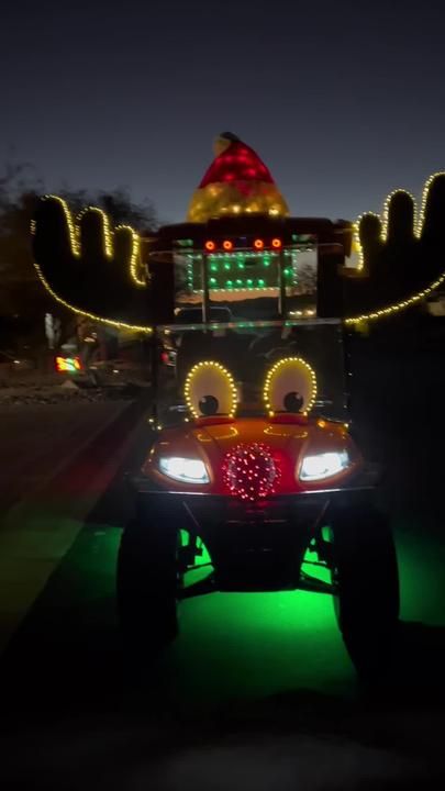 a vehicle decorated with christmas lights driving down the street