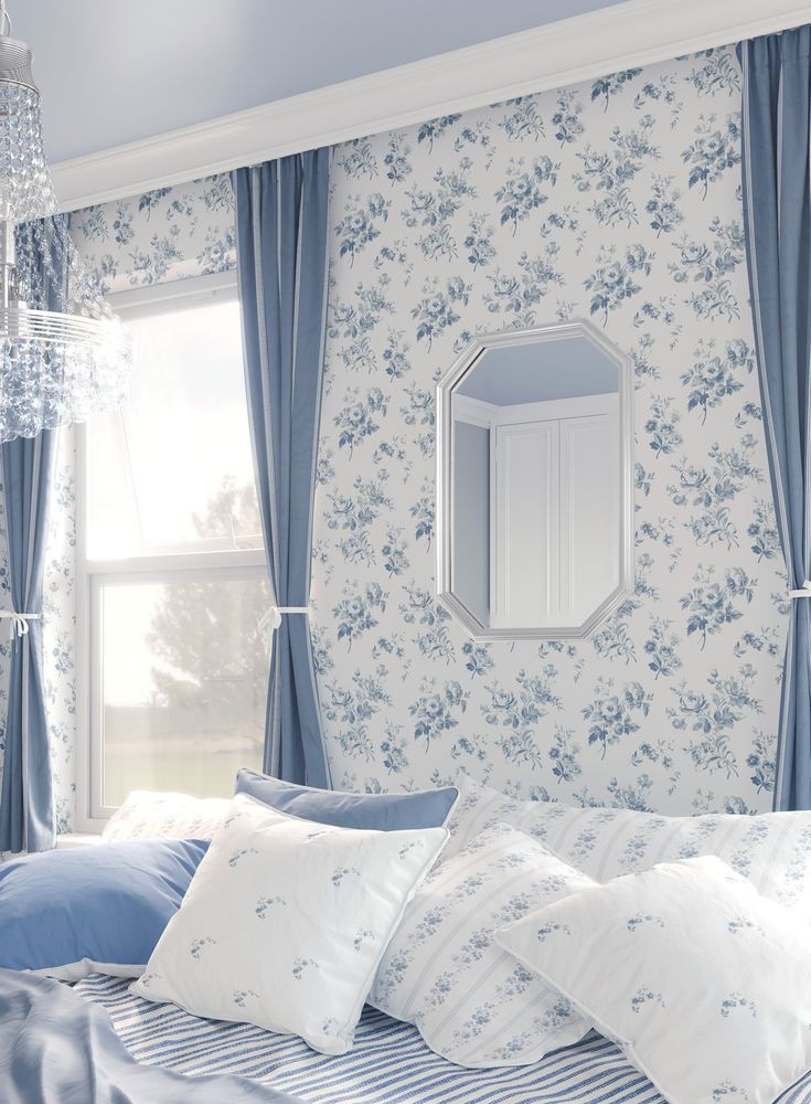 a bedroom with blue and white wallpaper, striped bedding, and a large mirror