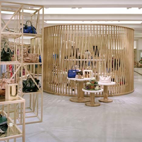 the inside of a women's clothing store with wooden shelves and baskets on display