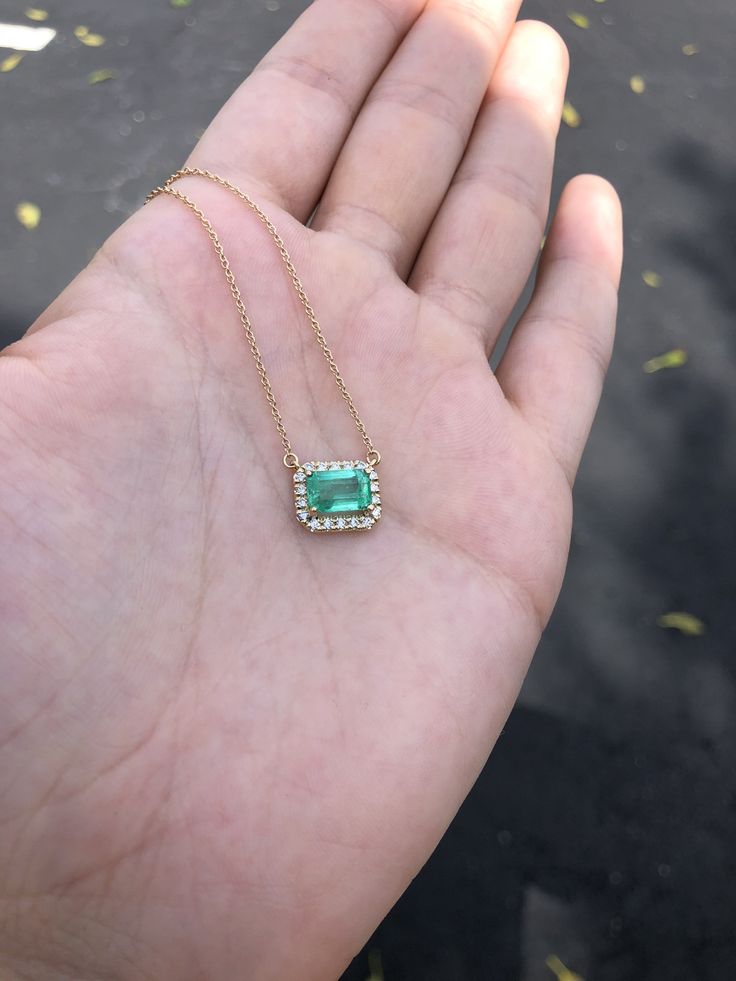 Featured here is a stunning East to West Colombian emerald and diamond halo necklace made in fine 14K yellow gold. Displayed is a lustrous, medium-light green with incredible transparency, accented by a simple four-prong 14K mount, allowing for the emerald to be shown in full view. Brilliant round diamonds halo around the emerald. The chain is stationary and is 18 inches long. This piece is ideal for everyday wear or for special occasions. Setting Style: Prong/ Pave Setting Material: 14K Yellow Green 14k Gold Jewelry With Single Cut Diamonds, 14k Gold Necklace With Emerald Cut Diamond Accents, Green Diamond Necklace With Halo Setting, Green Emerald Jewelry With Halo Detail, Green Necklace With Halo Setting For Wedding, Green Halo Setting Necklace For Wedding, Green Emerald Halo Jewelry, May Birthstone Jewelry With Single Cut Diamonds, Luxury Gold Emerald Jewelry With Single Cut Diamonds