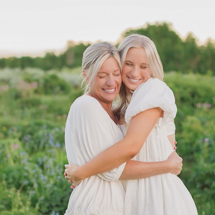 two women hugging each other in a field