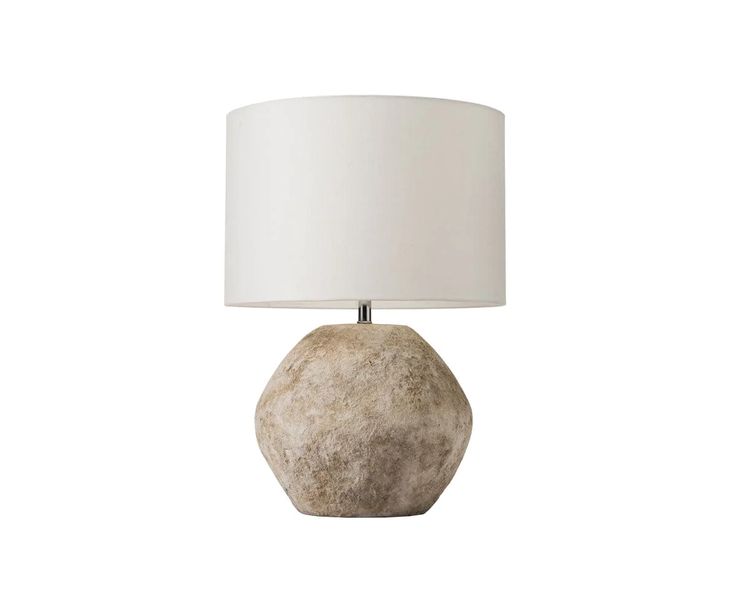 a stone lamp with a white shade on it