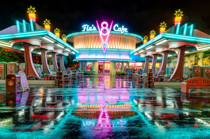 the entrance to a casino at night with neon lights on it's sides and brightly lit signage