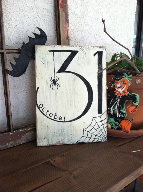 a wooden sign sitting on top of a table next to a potted plant and window