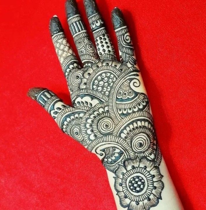 a hand with henna tattoos on it