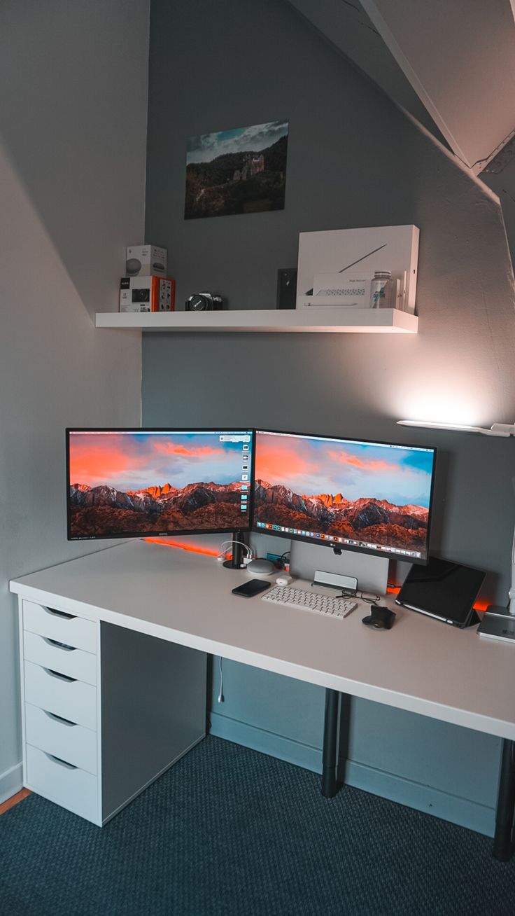 two computer monitors sitting on top of a white desk