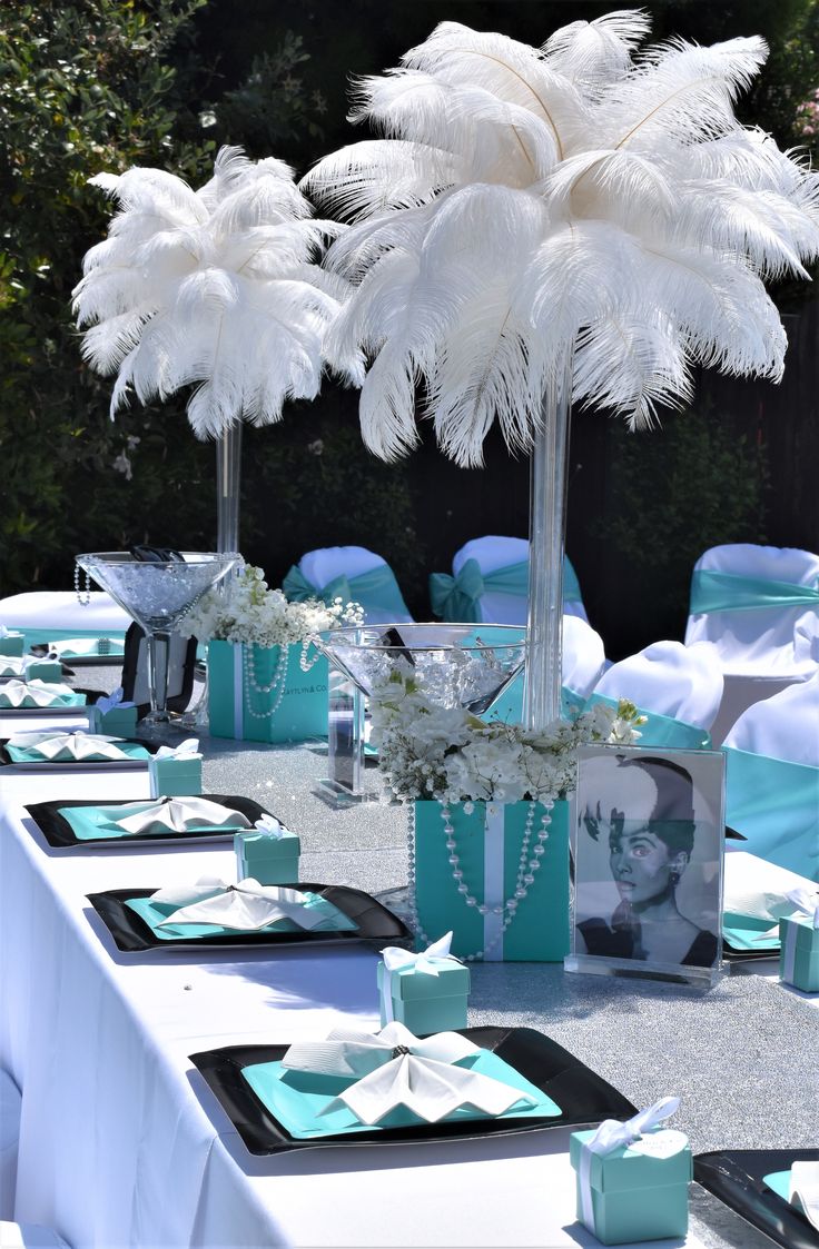 the table is set up with blue and white decorations for an outdoor wedding reception,