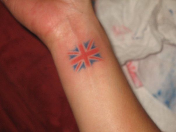 a person with a small tattoo on their left arm and the british flag on her right wrist