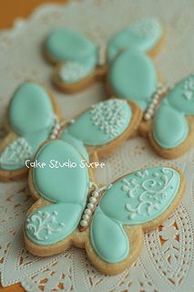 cookies decorated with blue icing and white lace on a doily tablecloth,