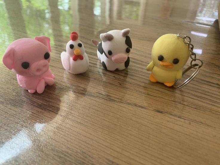 four little toy animals sitting on top of a wooden table