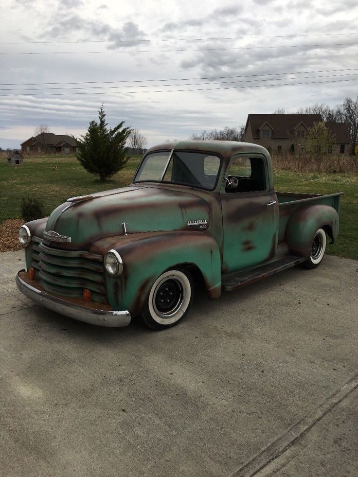 an old rusty truck parked in a parking lot