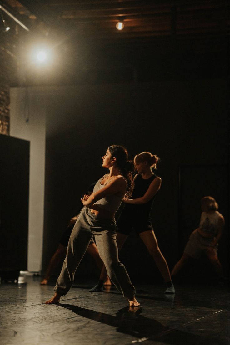 two dancers in the middle of a dance class, one is holding her leg up