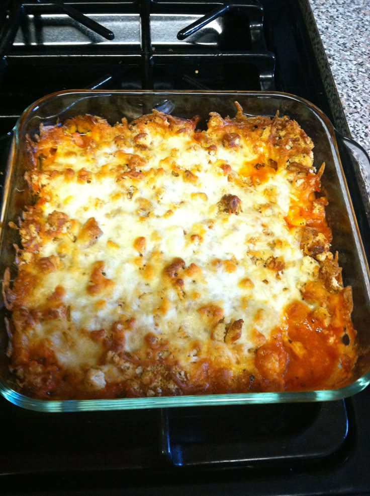 a casserole dish sitting on top of a stove in a glass baking pan