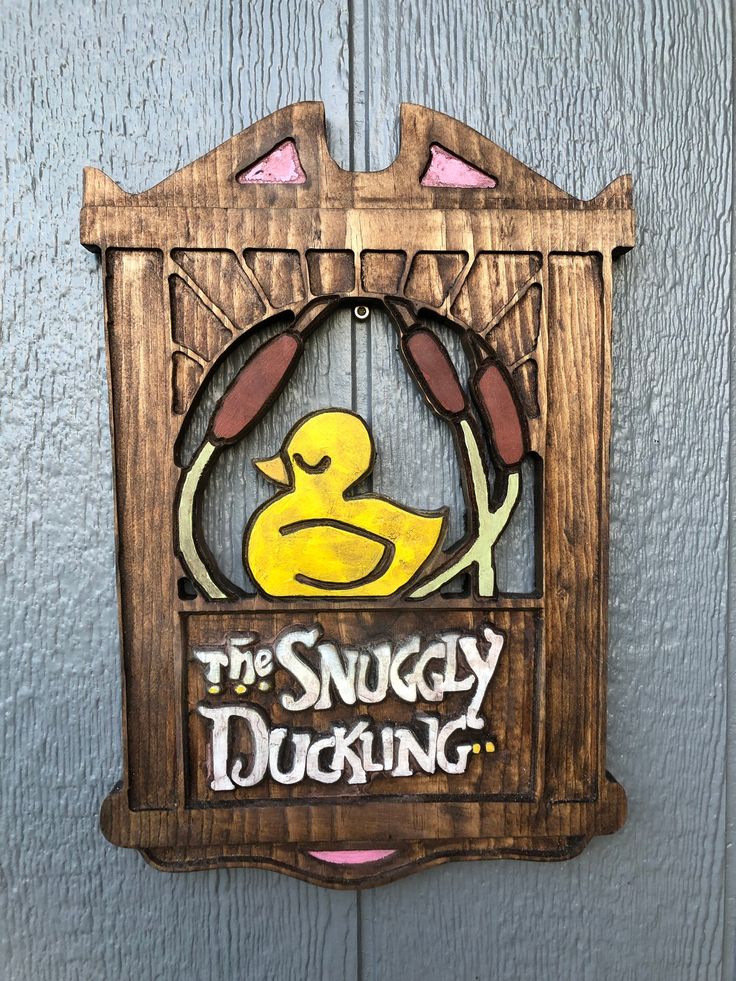 a wooden sign that says the snuggley duckling on it's side