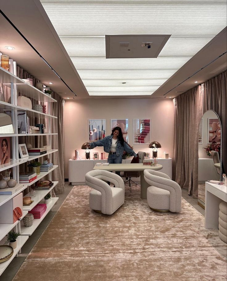 a woman standing in the middle of a living room filled with furniture and bookshelves