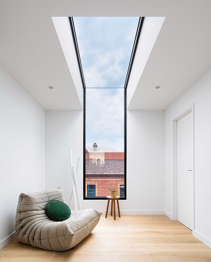 a room with a large window and a bean bag chair in the middle of it