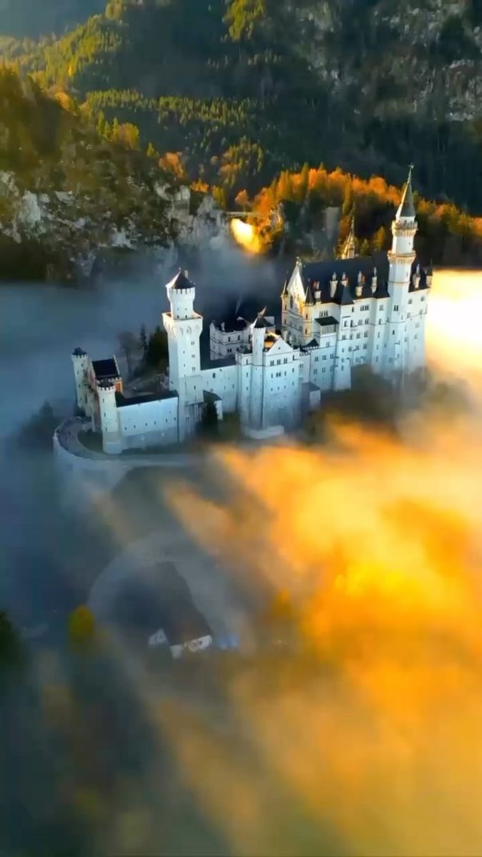 an aerial view of a castle surrounded by fog