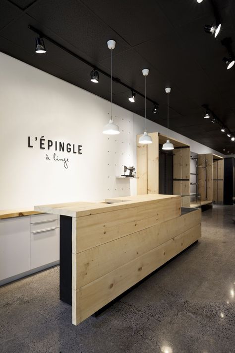 an empty room with lights hanging from the ceiling and wooden counter in front of it