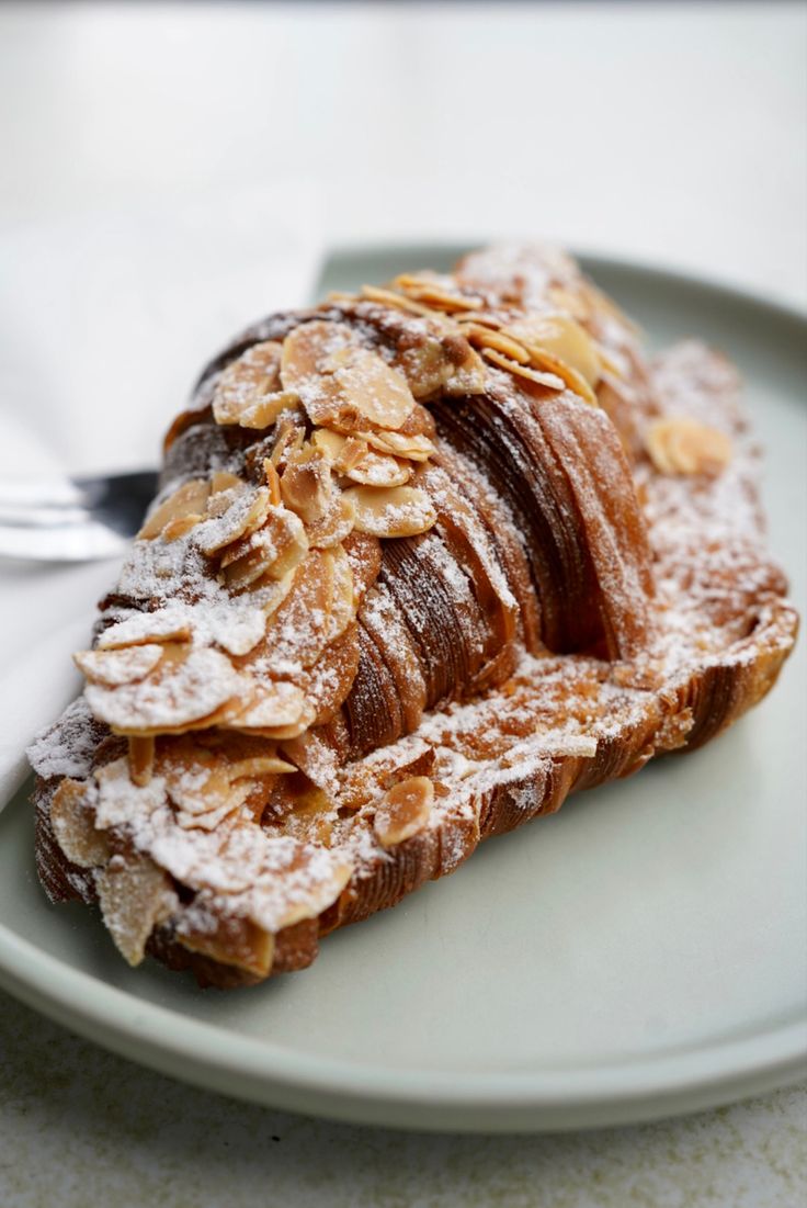 a white plate topped with pastry covered in powdered sugar