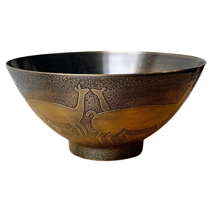 a metal bowl with an animal design on it