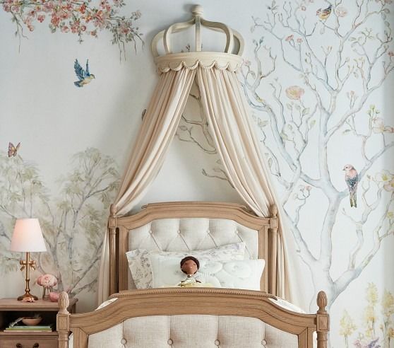 a child's bedroom with a canopy bed and floral wallpaper on the walls