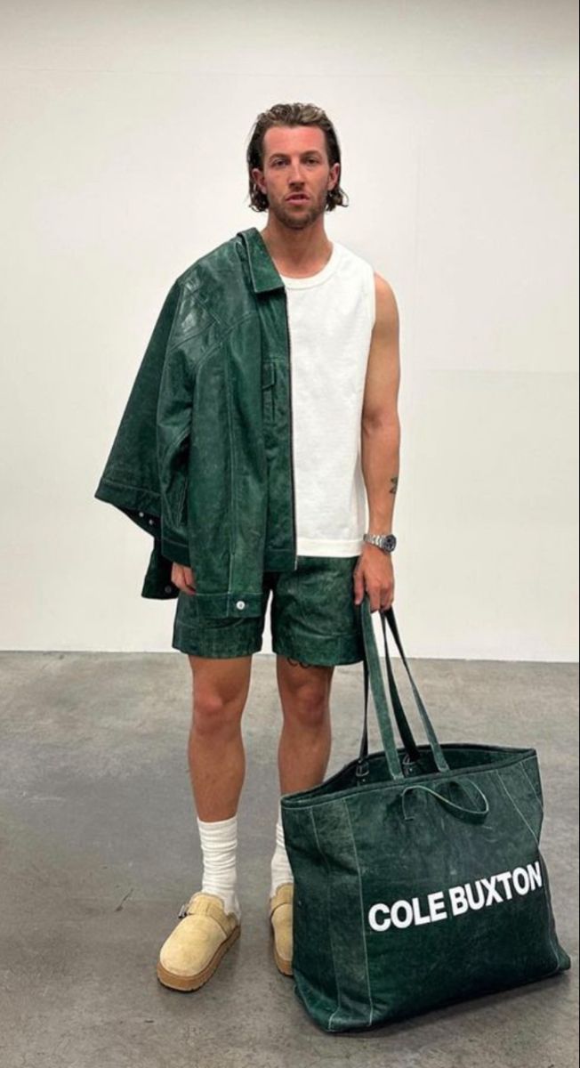 a man in green shorts holding a large bag