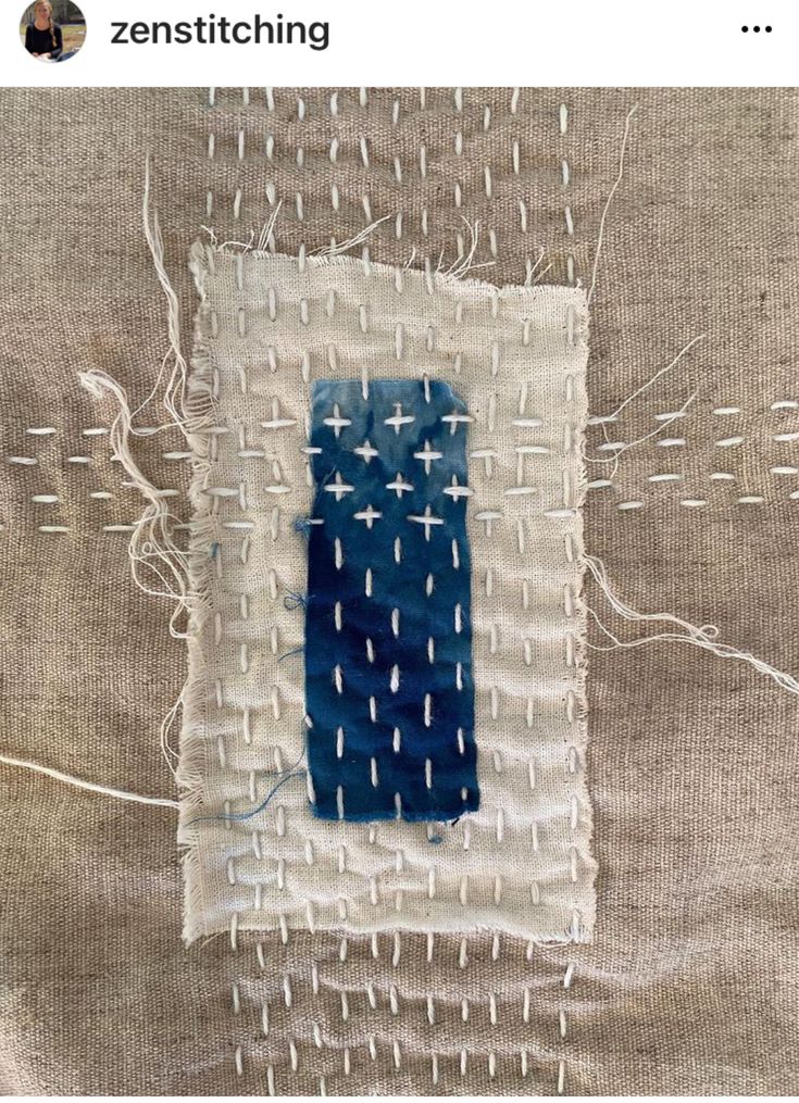 a piece of fabric that has been stitched together with white thread and blue paint