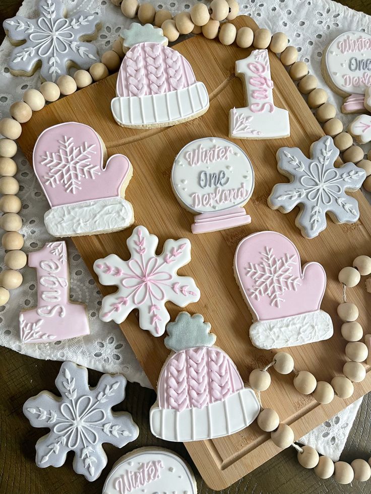 decorated cookies are displayed on a cutting board with beaded trimmings and snowflakes