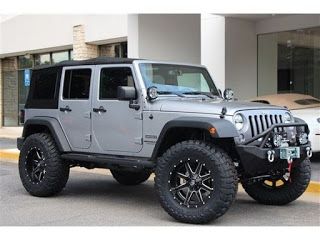 a gray jeep parked in front of a building