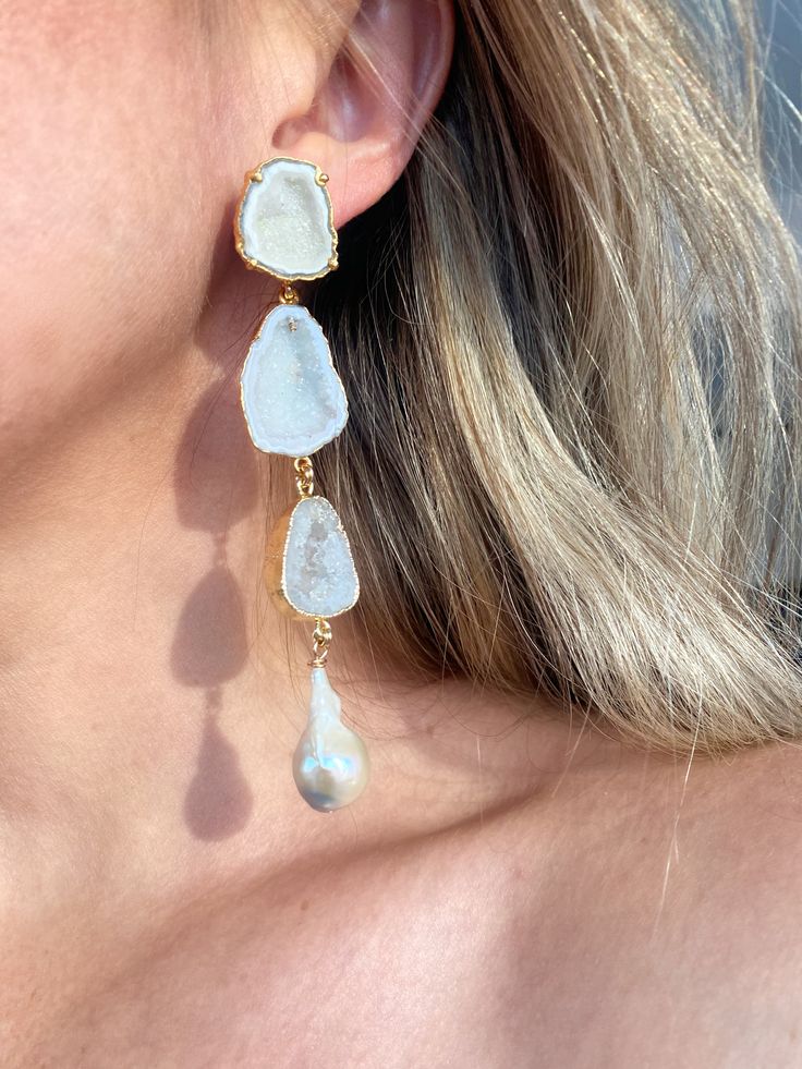 Edith earrings are a showstopper! They feature white geode posts set in gold with cascading geodes in shades of white and a single cream keshi pearl on each side. They are stunning and still lightweight. We hand select the most beautiful stones that are also on the thinner side to keep them comfortable for the ear. These are a favorite among brides! Approximately 4.5” in length. Please note each pair will differ slightly as no two stones are ever exactly the same. Luxury White Earrings With Gemstone Accents, Unique White Dangle Pearl Earrings, White Natural Stones Earrings For Wedding, White Natural Stone Wedding Earrings, White Natural Stone Pearl Earrings For Wedding, White Pearl Earrings With Natural Stones For Wedding, Elegant White Earrings With Gemstone Accents, White Gemstone Party Earrings, Unique White Drop Jewelry