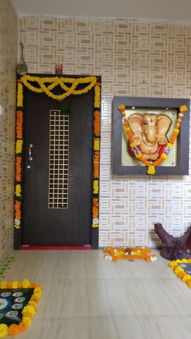 an entrance decorated with flowers and gandapa in front of a door to another room