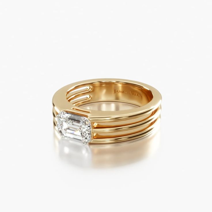 a rose gold ring with an emerald stone in the center and three thin bands around it