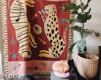 a tapestry hanging on the wall next to a potted plant and other items in front of it