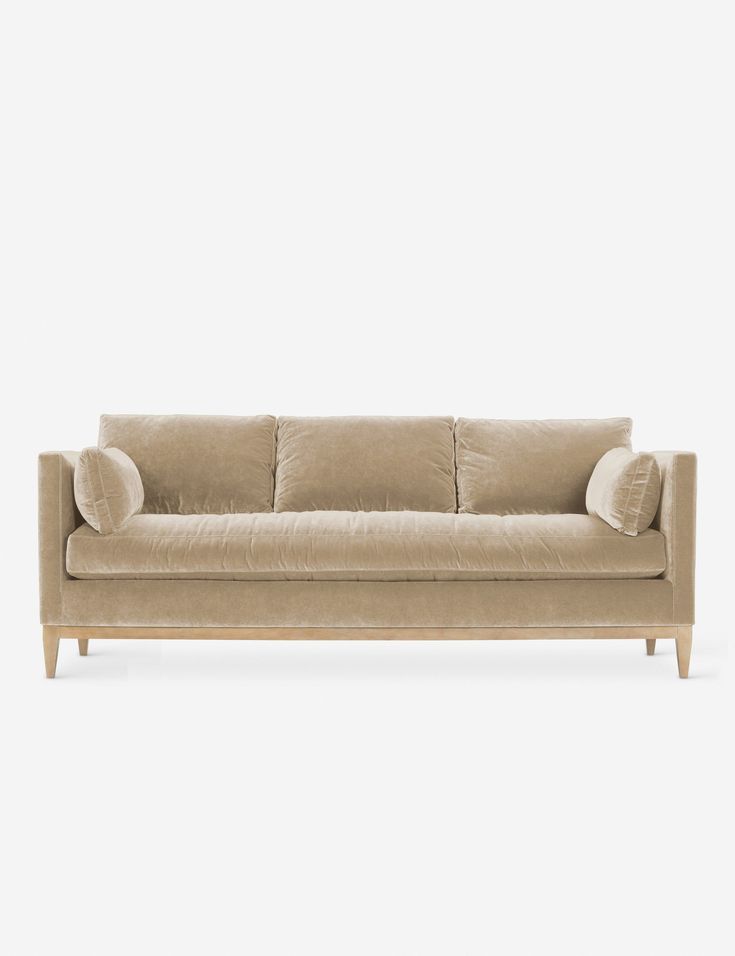 a beige couch sitting on top of a white floor