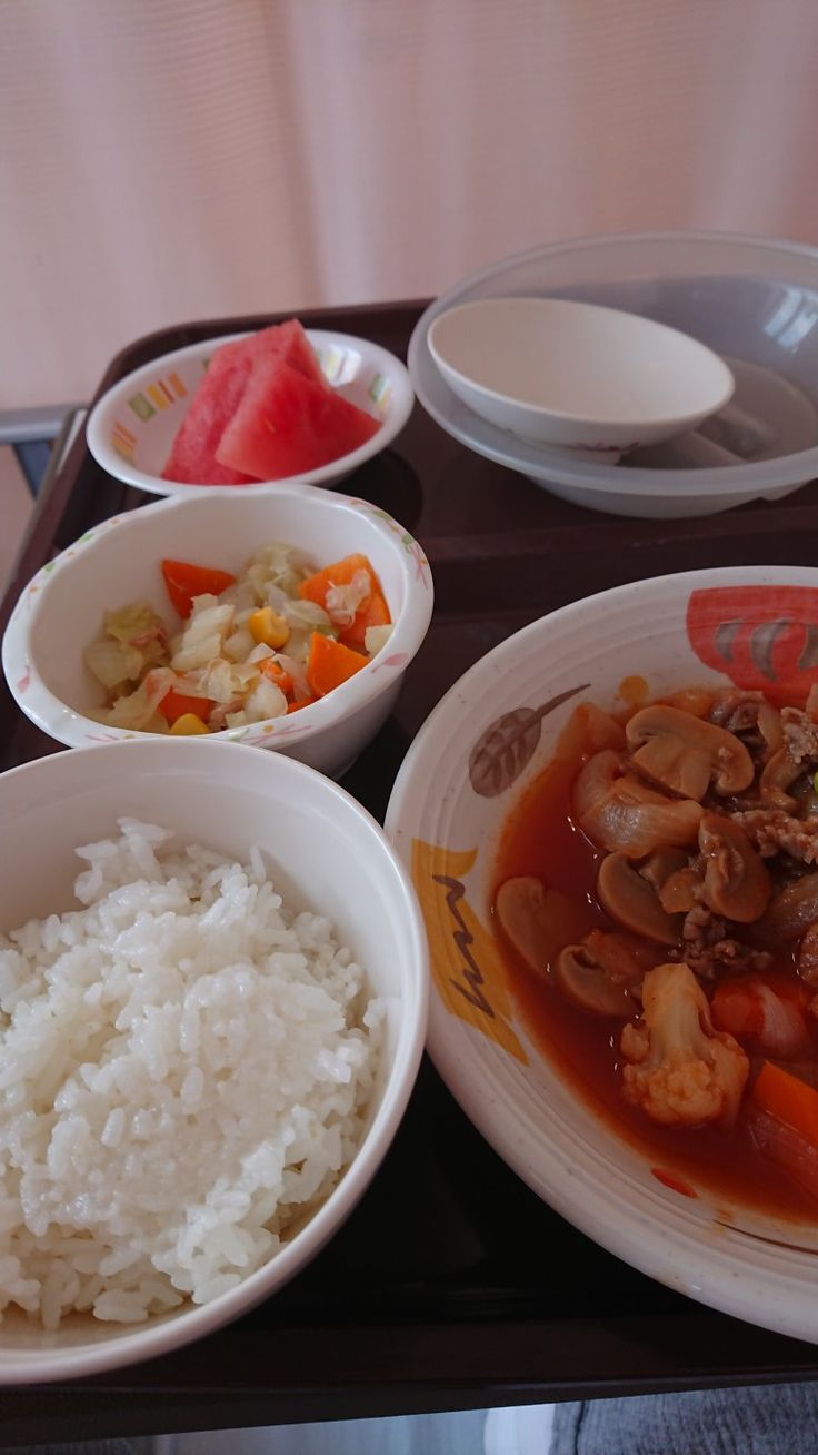 a tray with rice, meat and vegetables on it