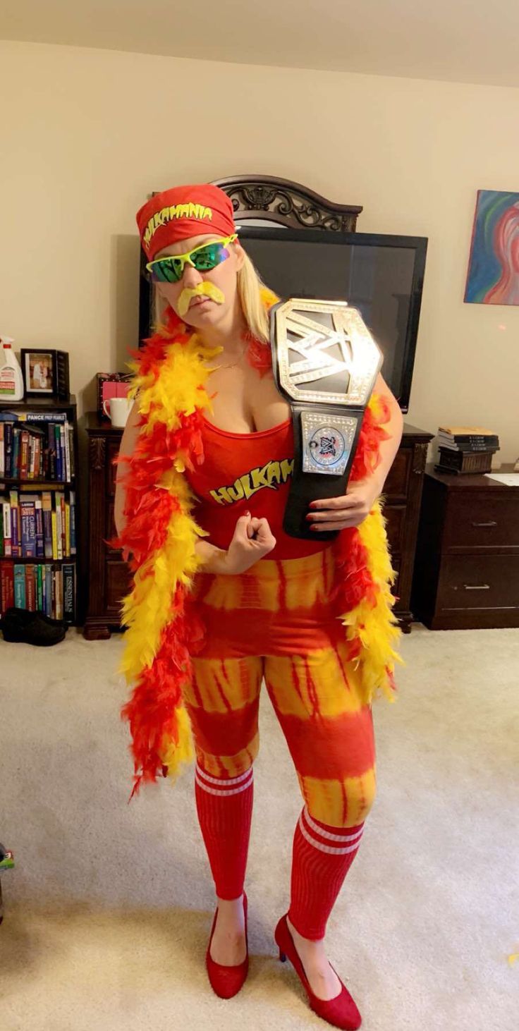 a woman dressed as a wrestler in a living room with a tv and bookshelf behind her