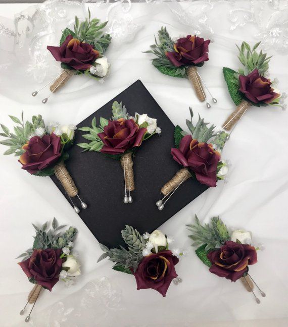 a graduation cap with flowers and greenery on it is surrounded by other boutions